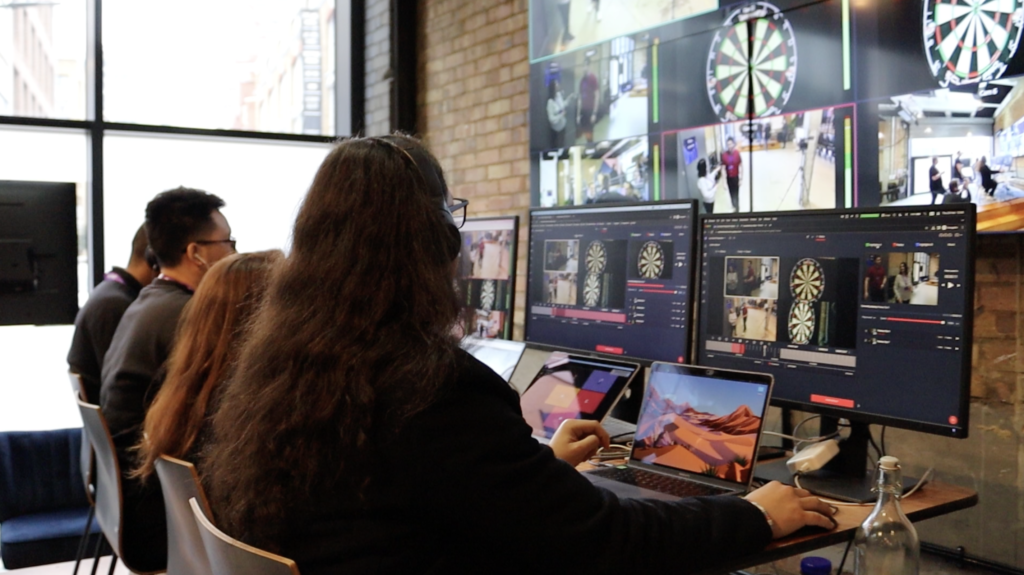 An image of four people in front of laptops and monitors using Grabyo video production software during a live multi-cam production